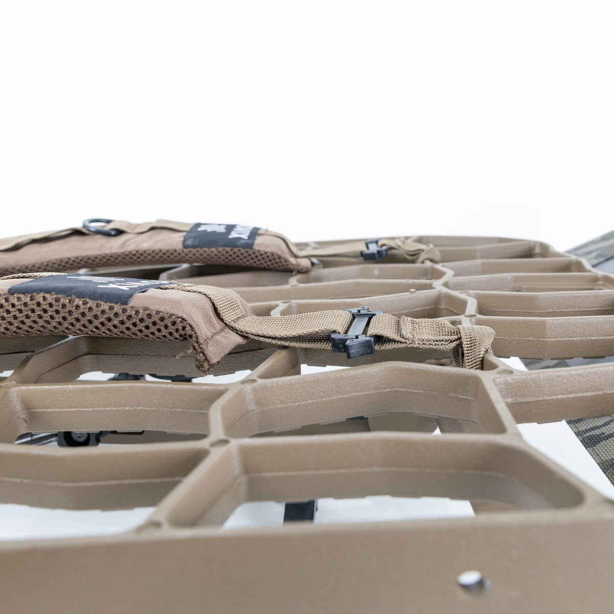 Close-up of a tan and gray outdoor hammock with integrated ventilation mesh panels and adjustable straps, shown against a clean white background.